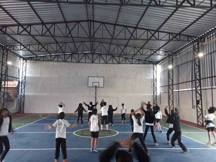 Alunos em aula de Educação Física na quadra coberta