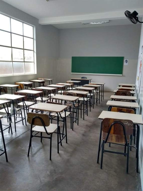 Sala de aula com carteiras e lousa